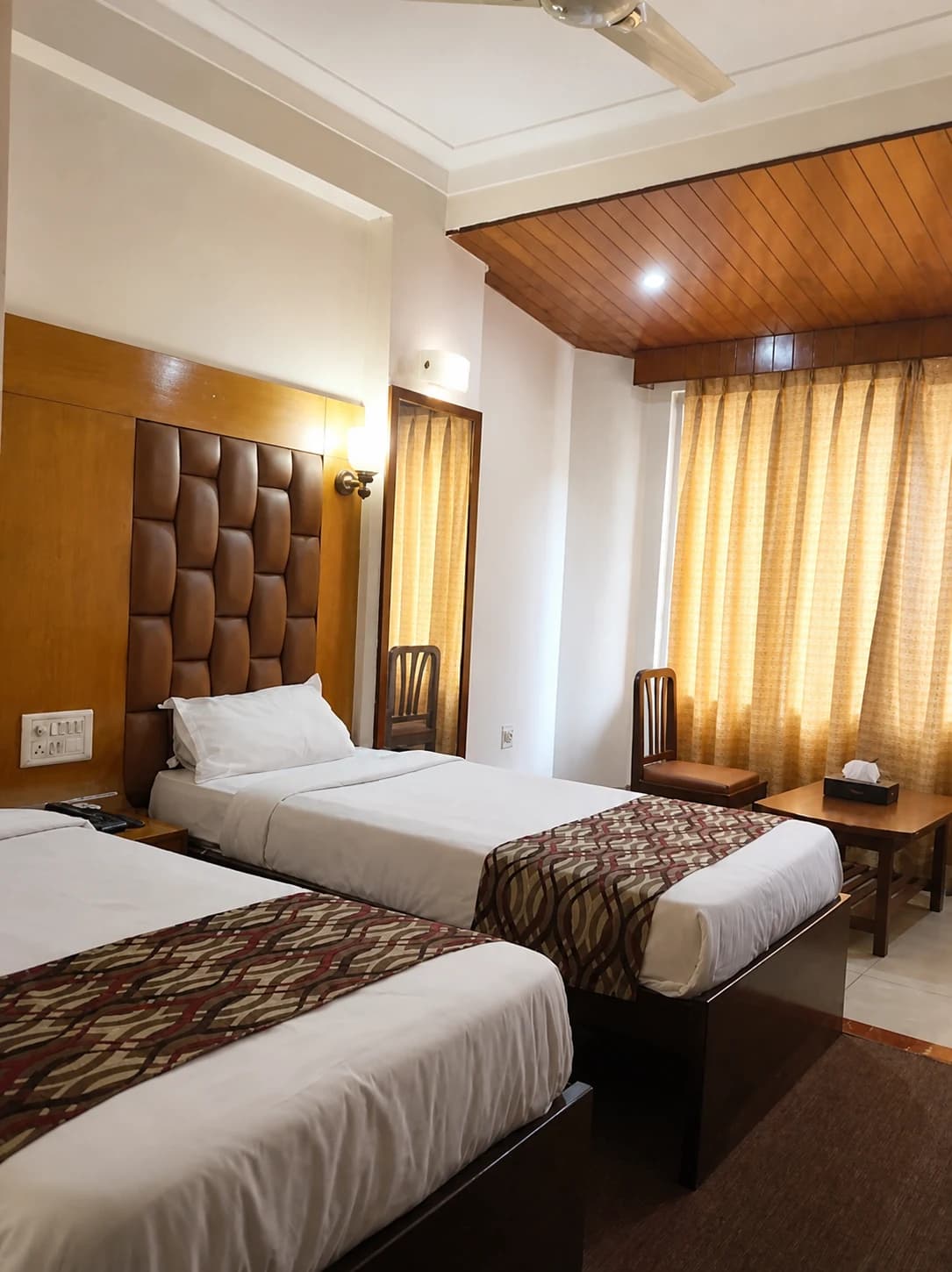 Deluxe Twin room vertical view showing bedside storage and lamps