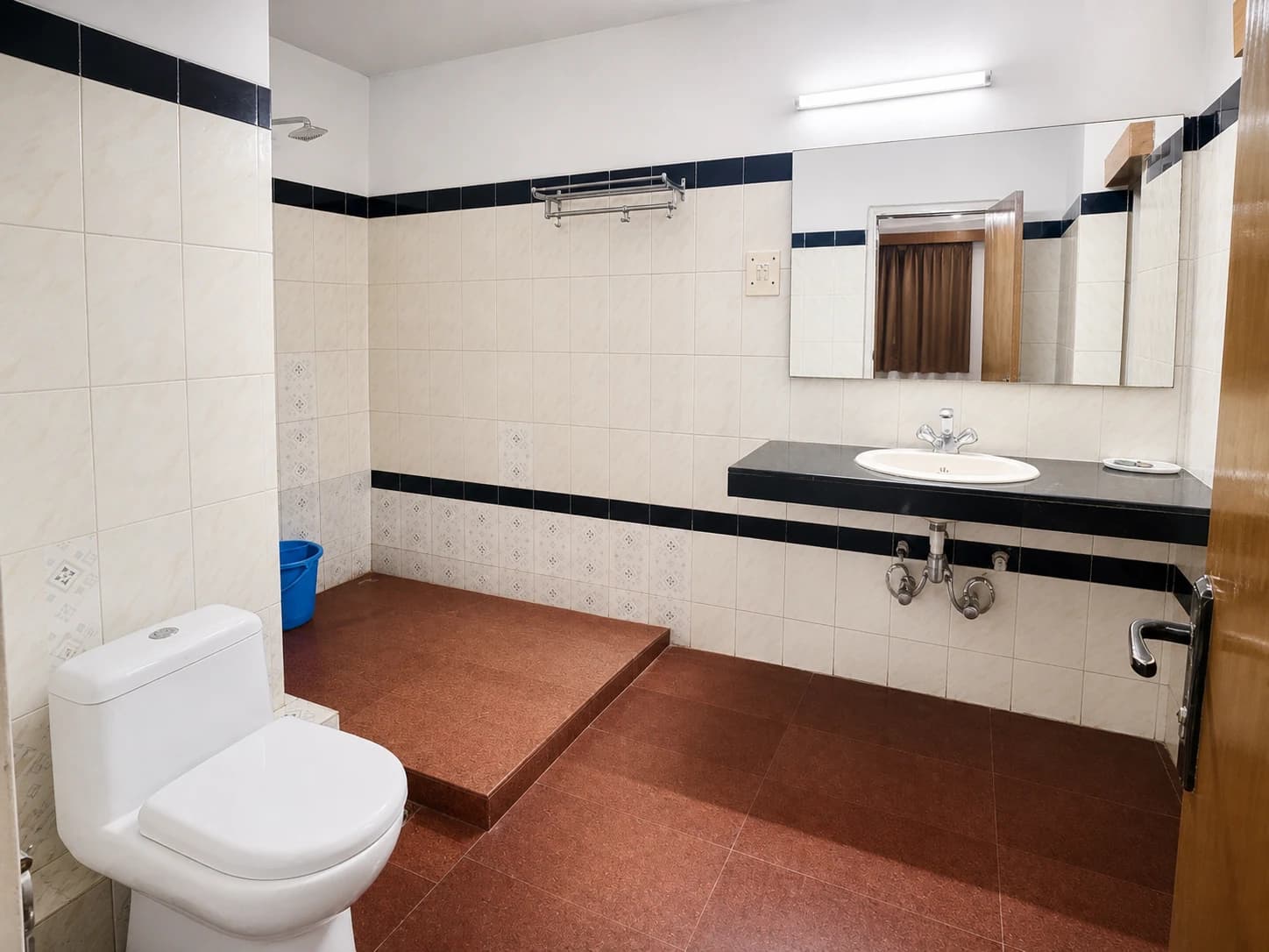 Clean modern bathroom with hot water geyser and vanity mirror